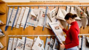 Eine junge Frau liest eine Zeitung